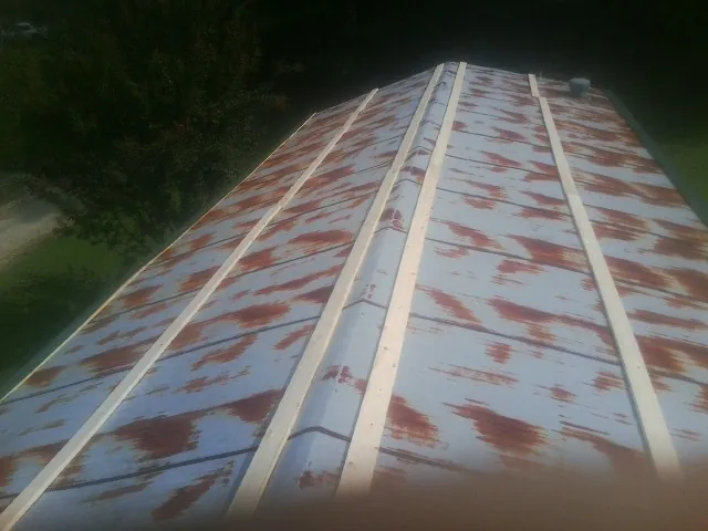 Rusted metal roof panels with new wood purlins before replacement — Storm Damage Roof Repair in Rush Springs by Roofing Brothers