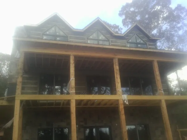Dormers and porch framing on a large log home under construction — Roof Coating work by our crew in Rush Springs
