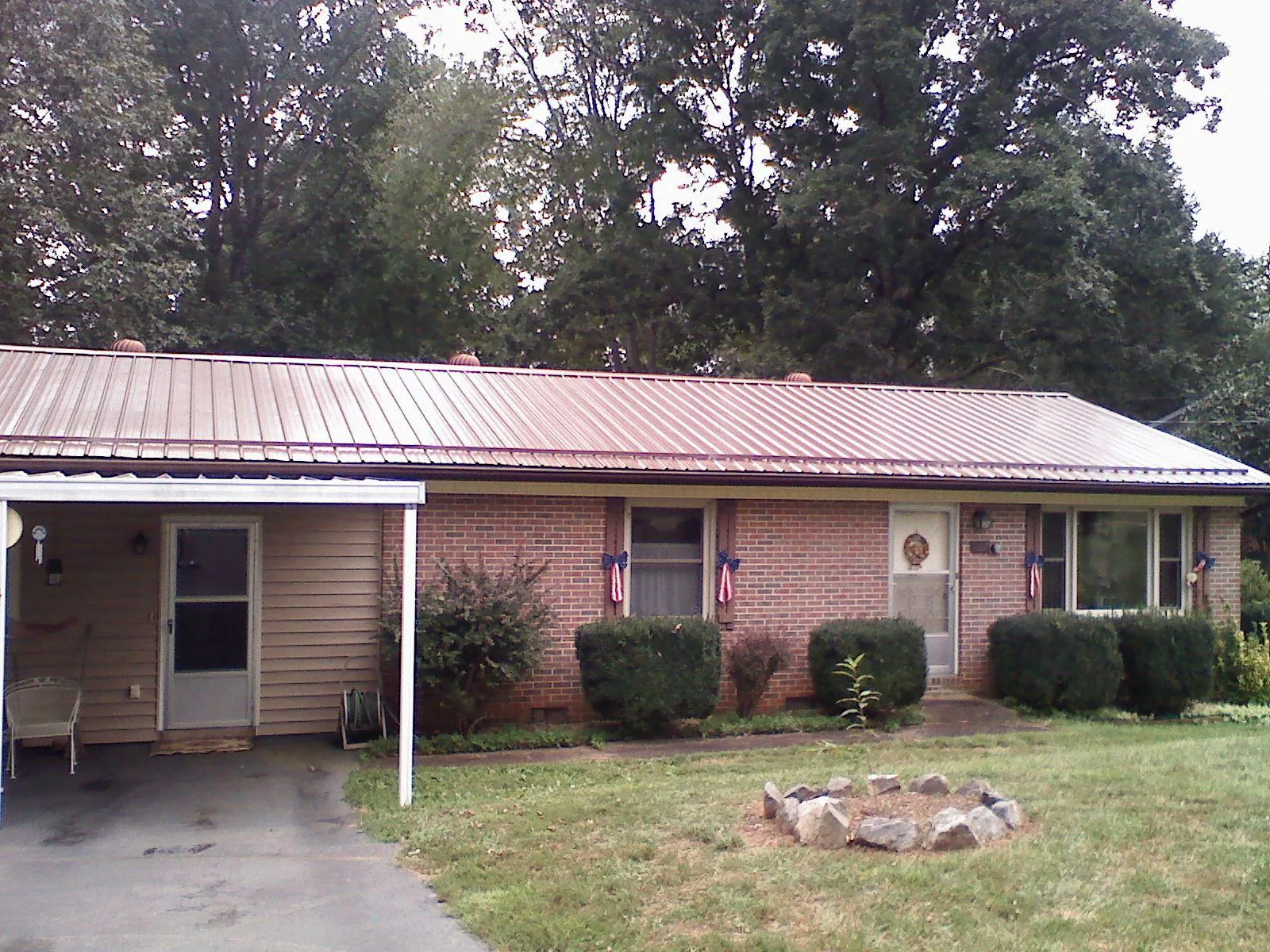 Bronze metal roof and carport on a brick ranch home — Roof Repair work by our crew in Rush Springs
