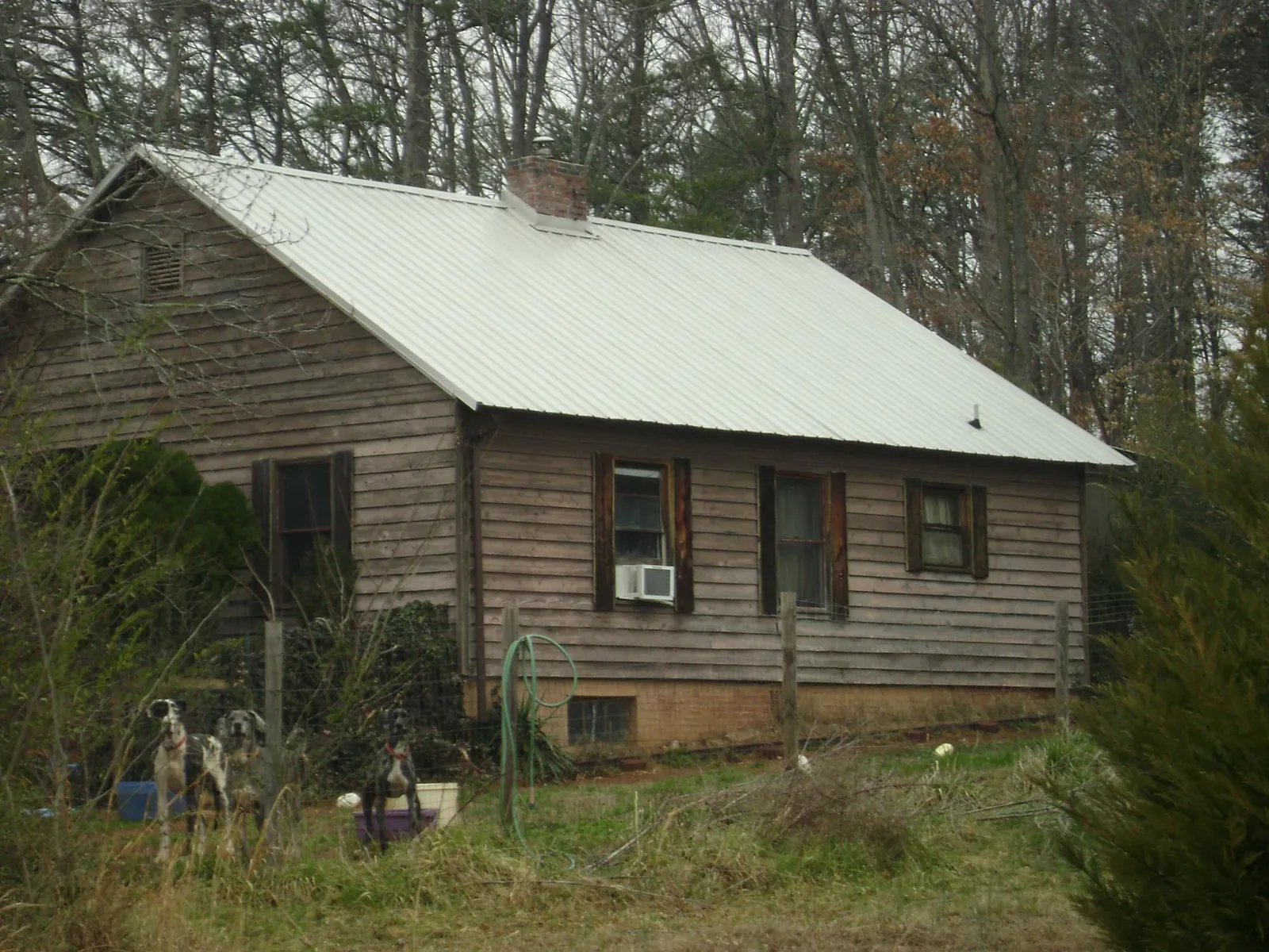 White metal roof on an old wood sided farmhouse, from a Asphalt Shingle Roof Repair job in Rush Springs